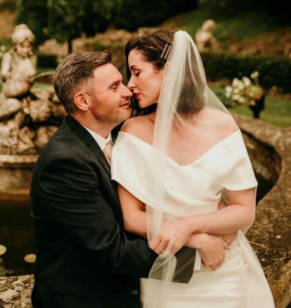 Сouple wearing a white gown and a black suit